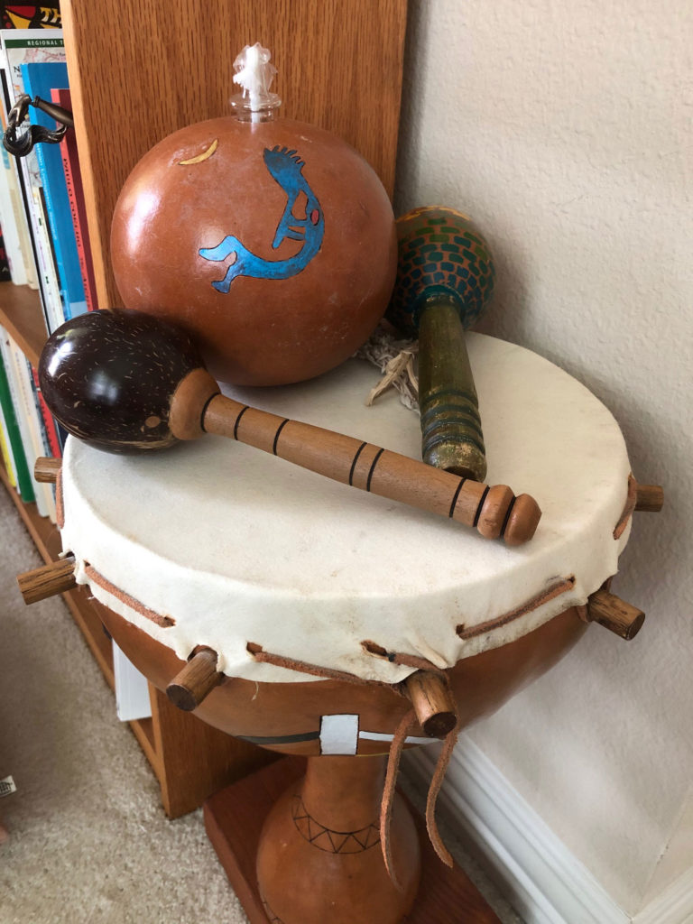 Several wooden maracas sitting on a hand drum.